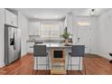 Bright kitchen with white cabinetry, granite countertops, stainless steel appliances, and bar seating at 215 Seventh St, Wake Forest, NC 27587