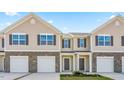 Inviting townhouse exteriors featuring stone accents, individual garages and neat landscaping at 279 Canopy Dr, Graham, NC 27253