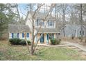 Exterior view of charming home featuring blue shutters, porch, and a tranquil, wooded front yard at 3323 Nantuckett Ave, Durham, NC 27703