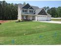 Charming two-story home features a three-car garage and a well-manicured lawn at 358 Coats Ridge Dr, Benson, NC 27504