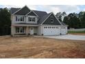 Inviting two-story home with a three-car garage and a welcoming front porch, perfect for relaxing evenings at 358 Coats Ridge Dr, Benson, NC 27504