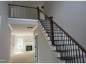 Elegant staircase with wood handrail and black metal balusters, leading to the second floor at 358 Coats Ridge Dr, Benson, NC 27504