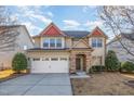 Charming two-story home featuring a two-car garage, stone accents, and a neatly manicured front lawn at 3910 Wedonia Dr, Cary, NC 27519