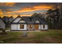 Charming single-Gathering home boasts a modern farmhouse design and inviting front porch at sunset at 4017 Mebane Oaks Rd, Mebane, NC 27302