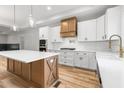 Bright kitchen with white cabinetry, wood accents, an island, and stainless steel appliances at 4017 Mebane Oaks Rd, Mebane, NC 27302