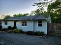 Quaint home featuring a well-manicured lawn, gravel driveway, and lovely landscaping at 424 S Greensboro St, Carrboro, NC 27510
