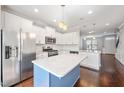 Modern kitchen features stainless steel appliances, white cabinets, and a blue island at 6233 Pesta Ct, Raleigh, NC 27612