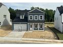 Two story home featuring blue siding, white trim, black roof, and an attached two car garage at 704 Compeer Way # 28, Rolesville, NC 27571