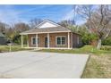 Exterior view of house featuring concrete driveway and grassy lawn at 735 Alexander Ave, Henderson, NC 27536
