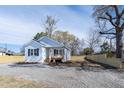 Quaint single-story home with a gravel driveway, a front porch, and a newly constructed wood fence at 818 E Holly St, Rocky Mount, NC 27801