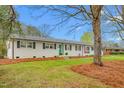 Charming single-story home featuring a well-manicured lawn, classic black shutters, and an inviting turquoise front door at 928 Hanford Rd, Graham, NC 27253