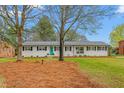 Charming single-story home featuring a well-manicured lawn, classic black shutters, and an inviting turquoise front door at 928 Hanford Rd, Graham, NC 27253