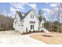Elegant home with a two-car garage, manicured landscaping, and a charming front porch at 100 High Ridge Ln, Pittsboro, NC 27312