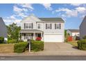 Traditional two-story home featuring a well-kept front yard, landscaping, and attached garage at 1009 Limeberry Ct, Clayton, NC 27520