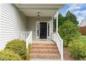 Inviting front porch features brick steps and white railings leading to a classic black front door at 101 Lager Ln, Garner, NC 27529