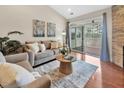 Bright living room featuring hardwood floors, a comfortable sofa, and sliding glass doors to the balcony at 10411 Rosegate Ct # 304, Raleigh, NC 27617