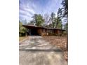 View of home's driveway with attached carport, offering covered parking and convenience at 1115 Park Ave, Henderson, NC 27536