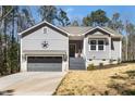 Charming exterior of a gray home with a gray garage door and beautiful front yard at 139 Oswego Dr, Louisburg, NC 27549