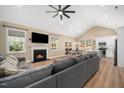 Open concept living room featuring vaulted ceiling, fireplace, and seamless flow to kitchen and dining areas at 139 Oswego Dr, Louisburg, NC 27549