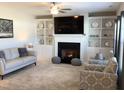 Inviting living room with a cozy fireplace, built-in shelving, and comfortable seating at 149 Steep Rock Dr, Willow Springs, NC 27592