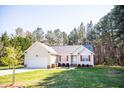 Charming single-story home with red shutters, attached garage, and manicured lawn at 1516 Bradsher Dr, Stem, NC 27581