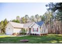Charming single-story home with red shutters, attached garage, and manicured lawn at 1516 Bradsher Dr, Stem, NC 27581