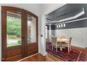 A dining room features a table set for four under a modern light fixture at 1721 Frenchwood Dr, Raleigh, NC 27612
