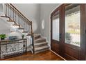 Elegant foyer featuring hardwood floors, a staircase with iron railings, and a stylish oval window at 1721 Frenchwood Dr, Raleigh, NC 27612
