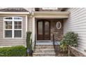 Inviting entryway with a beautiful stone facade, arched glass doors, and manicured landscaping at 1721 Frenchwood Dr, Raleigh, NC 27612