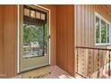 The front door has storm door and is framed by dark wood siding and brick entryway at 1801 Irish Blvd, Sanford, NC 27332