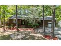 Inviting single-story home featuring an American flag, brick accents, mature trees, and a beautifully landscaped front yard at 1801 Irish Blvd, Sanford, NC 27332