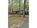 Charming single-story home with a neatly landscaped front yard, a gravel driveway, and mature trees providing ample shade at 1801 Irish Blvd, Sanford, NC 27332