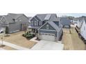 Aerial view of a two-story home featuring a two-car garage, manicured lawn, and covered porch at 1916 Edens Ridge Ave, Wake Forest, NC 27587