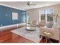 Cozy living room features a blue accent wall, stylish furniture, hardwood flooring, and lots of natural light at 201 Finsbury St # 201, Durham, NC 27703