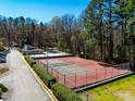 Community tennis courts and swimming pool surrounded by lush landscaping and tall trees at 220 Elizabeth St # F-2, Chapel Hill, NC 27514