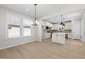 Open dining room featuring hardwood floors with view of kitchen with island and pendant lighting at 2340 Beeblossom Pl, Fuquay Varina, NC 27526