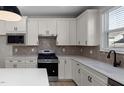 Bright kitchen with white cabinets, stainless steel appliances, and tile backsplash at 2340 Beeblossom Pl, Fuquay Varina, NC 27526