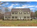 Charming two-story home features a well-manicured lawn and classic architecture under a bright, partly cloudy sky at 250 Spring View Ln, Pittsboro, NC 27312