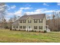 Charming two-story home features a well-manicured lawn and classic architecture under a bright, partly cloudy sky at 250 Spring View Ln, Pittsboro, NC 27312