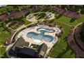 Aerial view of a community pool, playground, and walking paths nestled in a lush green landscape at 3015 Dog Rose Drive Lot 170 Dr, Durham, NC 27703