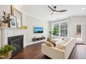 Bright living room with a cozy fireplace, hardwood floors, and a large window at 3929 Glenlake Garden Dr, Raleigh, NC 27612