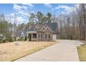 Two-story home with a stone facade, covered porch, and long private driveway at 442 Hunters Pointe Rd, Nashville, NC 27856