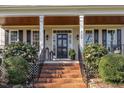 Elegant front entrance featuring brick steps, black door, stylish lanterns, and well-maintained landscaping at 4704 Homeplace Dr, Apex, NC 27539