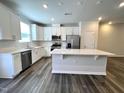 Modern kitchen features stainless steel appliances, white cabinets, a subway tile backsplash, and an island with countertop seating at 5014 Kota St, Raleigh, NC 27610