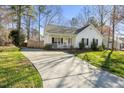 Long driveway leading to a charming single-story home with a welcoming front porch at 513 Jaffiley Ct, Wake Forest, NC 27587