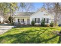 Charming single-story home with a welcoming front porch, lush lawn, and mature trees at 513 Jaffiley Ct, Wake Forest, NC 27587