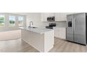 Bright kitchen featuring a large island with sink and quartz countertops and stainless steel appliances at 605 Silverado Sunset Loop, Wendell, NC 27591