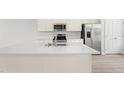 Open kitchen featuring stainless steel appliances, large island with sink, and light wood floors at 609 Silverado Sunset Loop, Wendell, NC 27591