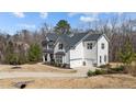 Side view of a beautiful two-story home with a three-car garage and a well-manicured lawn at 7100 Hasentree Club Dr, Wake Forest, NC 27587