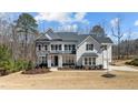 Beautiful two-story home with stone and white shingle siding, black shutters, and a well-manicured lawn at 7100 Hasentree Club Dr, Wake Forest, NC 27587